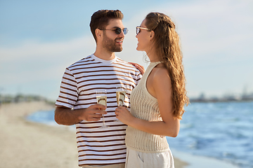 Image showing happy couple drinking champagne on summer beach