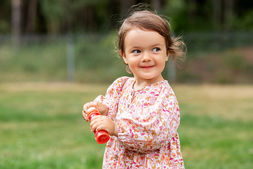 Image showing happy baby girl with soap bubble blower in summer