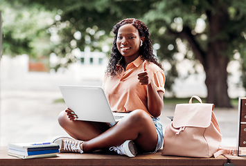 Image showing african student girl in earphones with laptop