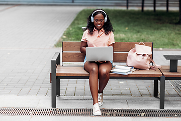 Image showing african student girl in headphones with laptop