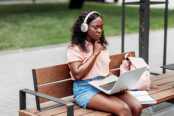 Image showing african student girl in headphones with laptop