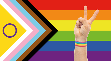 Image showing hand with gay pride rainbow wristband shows peace