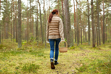 Image showing young woman picking mushrooms in autumn forest