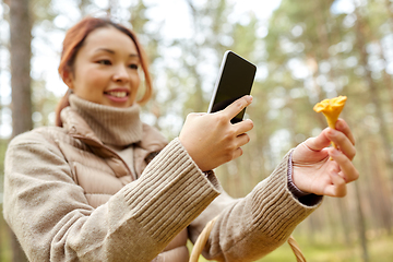 Image showing asian woman using smartphone to identify mushroom