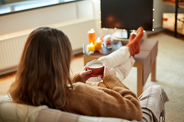 Image showing woman watches tv and drinks cocoa on halloween