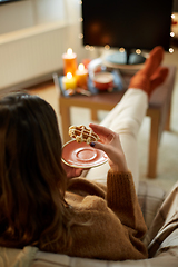 Image showing woman watching tv and eating waffle on halloween