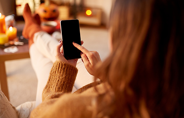 Image showing woman using smartphone at home on halloween