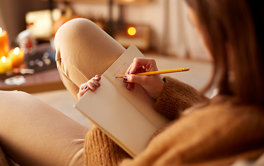 Image showing woman writing to diary at home on halloween