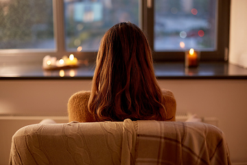 Image showing woman looking through window at home in autumn