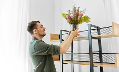 Image showing man decorating home with flowers in vase