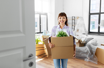 Image showing happy woman unpacking boxes and moving to new home