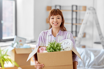 Image showing happy woman unpacking boxes and moving to new home