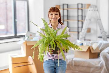 Image showing happy woman with fern flower moving to new home