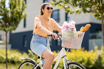 Image showing woman with food and flowers in bicycle basket