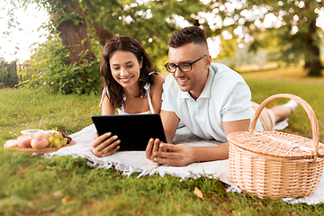 Image showing happy couple with tablet pc at picnic in park