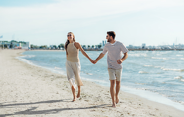 Image showing happy couple running along summer beach