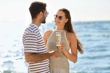 Image showing happy couple drinking champagne on summer beach