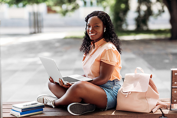 Image showing african student girl in earphones with laptop