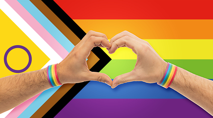 Image showing male hands with gay pride wristbands showing heart