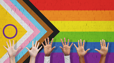 Image showing multiracial hands over progress pride flag