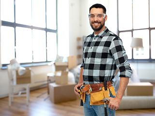 Image showing happy male builder with tool belt at home