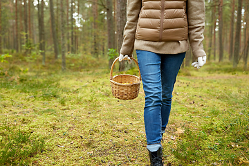 Image showing young woman picking mushrooms in autumn forest