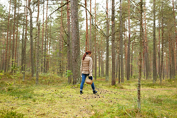 Image showing young woman picking mushrooms in autumn forest