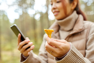 Image showing asian woman using smartphone to identify mushroom