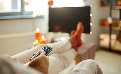 Image showing young woman watching tv at home on halloween