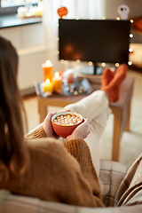 Image showing woman watches tv and drinks cocoa on halloween