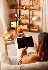 Image showing woman with tablet pc at home on halloween