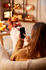 Image showing woman using smartphone at home on halloween