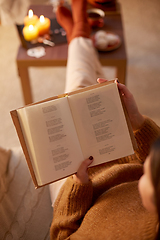 Image showing young woman reading book at home on halloween