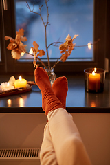 Image showing feet in socks on window sill at home in autumn