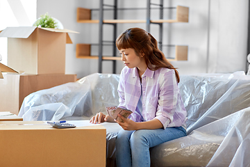 Image showing asian woman moving to new home and counting money