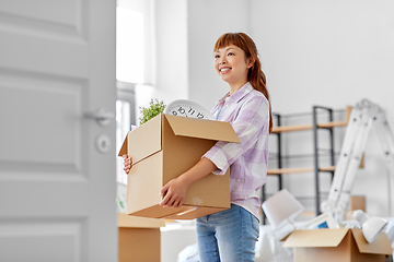 Image showing happy woman unpacking boxes and moving to new home