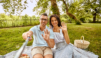 Image showing happy couple taking selfie at picnic in park