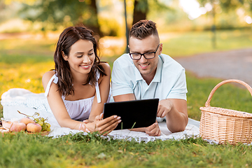 Image showing happy couple with tablet pc at picnic in park