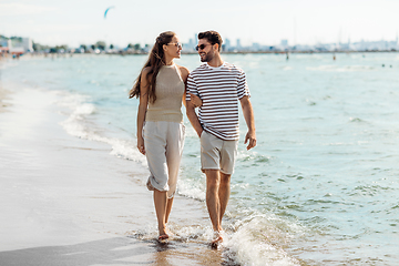 Image showing happy couple walking along summer beach