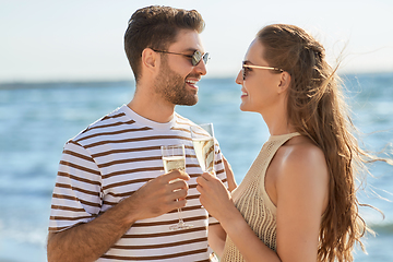 Image showing happy couple drinking champagne on summer beach