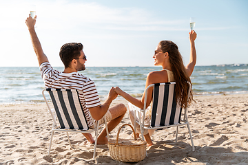 Image showing happy couple drinking champagne on summer beach