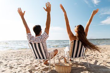 Image showing happy couple sitting in folding chairs on beach