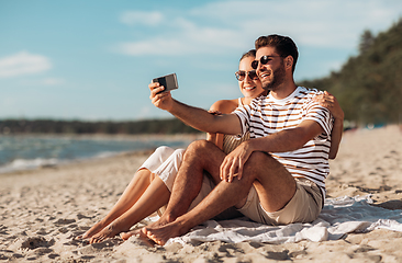 Image showing happy couple taking selfie by smartphone on beach