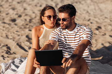 Image showing happy couple with tablet pc at on summer beach