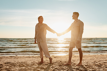 Image showing happy couple holding hands on summer beach