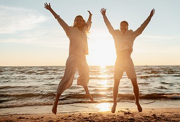 Image showing happy couple jumping on summer beach