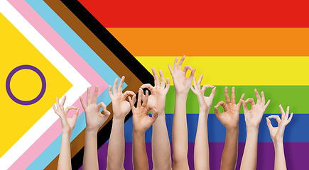 Image showing hands showing ok sign over progress pride flag