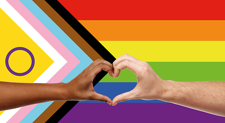 Image showing couple showing hand heart over progress pride flag