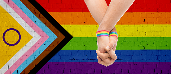 Image showing gay couple hands with over progress pride flag