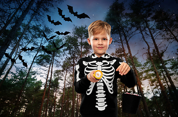 Image showing boy with candies and flashlight on halloween